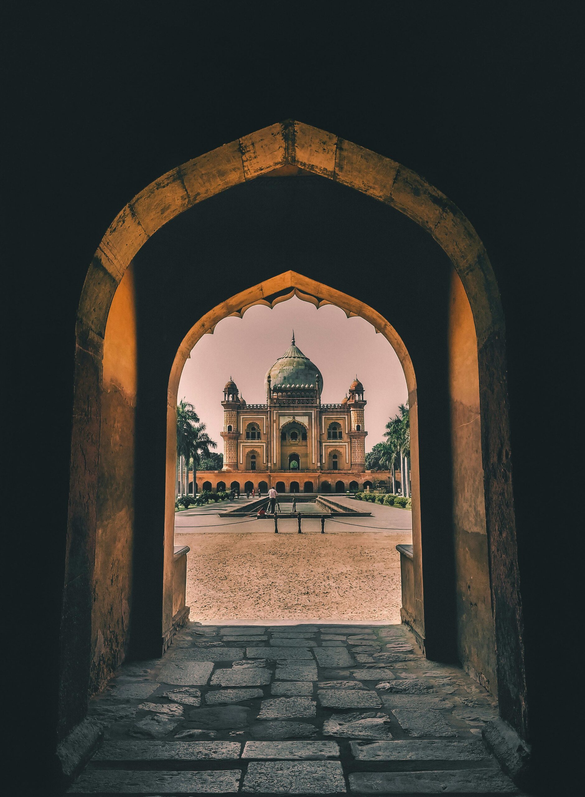 View through an arched hallway towards the historical Safdarjung Tomb in New Delhi, India.