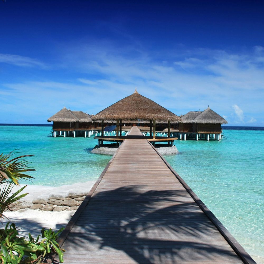 maldives ile beach sun 38238 38238 Scenic view of a wooden boardwalk leading to serene overwater bungalows at an island resort.