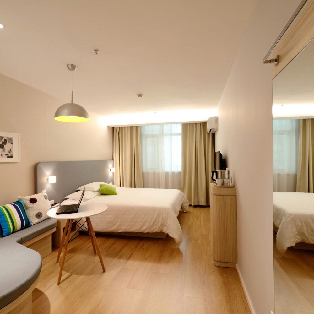 pexels photo 271624 271624 1 Spacious modern hotel room featuring cozy decor and neutral tones with natural light.